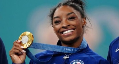 Simone Biles mostrando una medalla olímpica